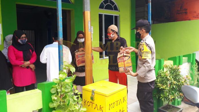 Personil Polsek Batu Ampar membagikan nasi kotak kepada masyarakat di wilayah hukum Polsek Batu Ampar, Jumat (27/11/2020). (Foto: Istimewa)