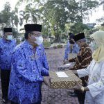 Hari Kesadaran Nasional, Sekda Asahan Ajak ASN Tingkatkan Kedisiplinan Sekda Asahan, Jhon Hardi Nasution (kiri), saat memberikan santunan kepada ASN yang memasuki masa pensiun.