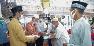 Jelang Lebaran, Pemkab Asahan dan BKM Masjid Agung Achmad Bakrie Kisaran Santuni Kaum Dhuafa dan Anak Yatim Pj Sekda Asahan Jhon Hardi Nasution (Kiri) secara simbolis memberikan santunan kepada kaum dhuafa dan anak yatim.