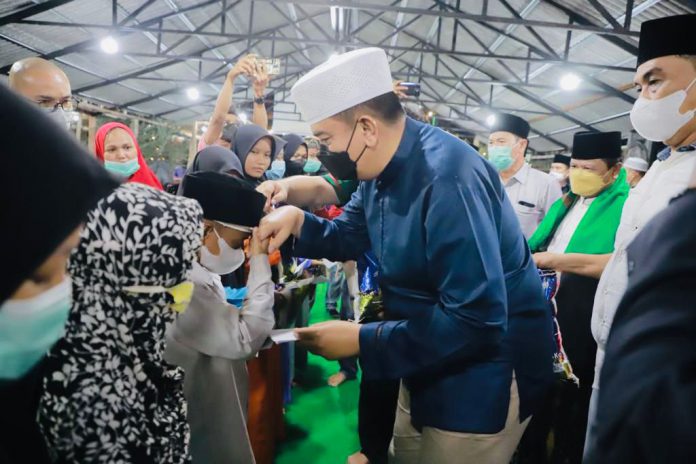 Ketua PWNU Riau, Budi Raharjo bersama Kapolda Riau Irjend Mohammad Iqbal bersalaman dengan anak yatim, Minggu (2/1/22). Foto: PWNU